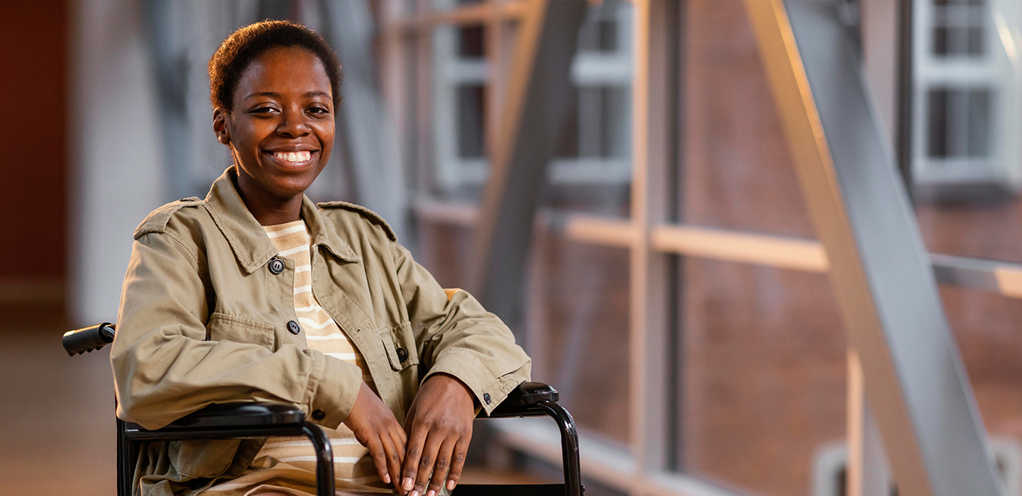 Young woman sitting on a wheelchair in an office block corridor