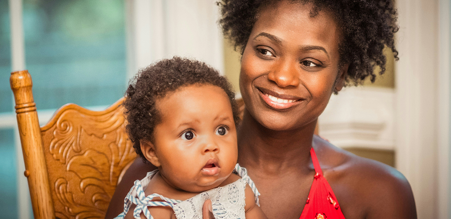 Mother sitting with child as they both smile