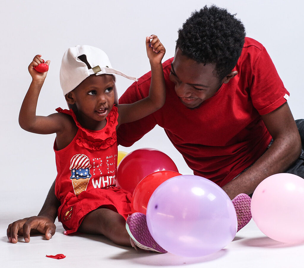 Father and young daughter playing with balloons