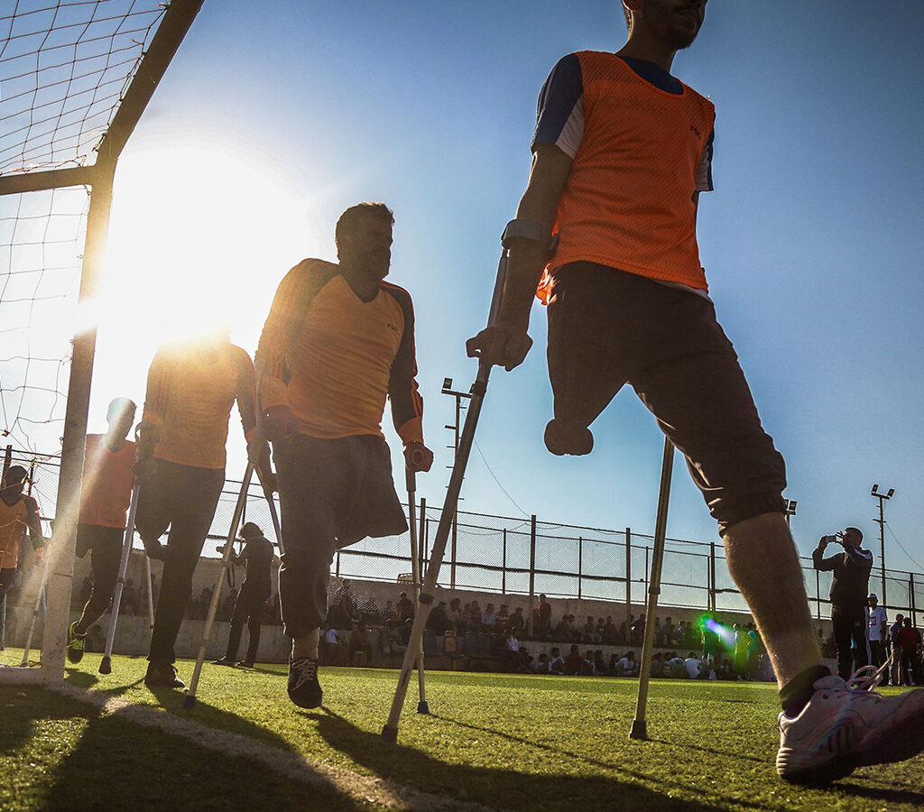 Silhouette of a team of football players using crutches